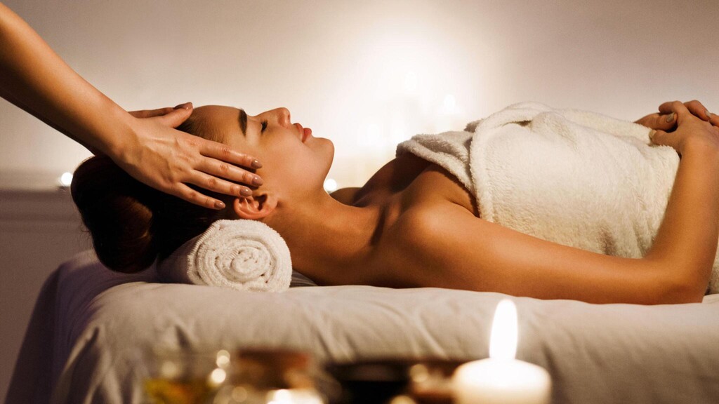 head massage with aromatic candles in salon.